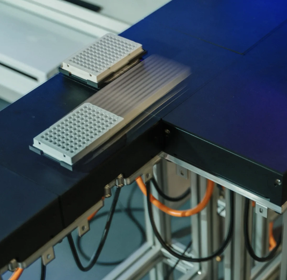 Image showing trays filled with protein solutions being transported across the laboratory on a magnetic platform.